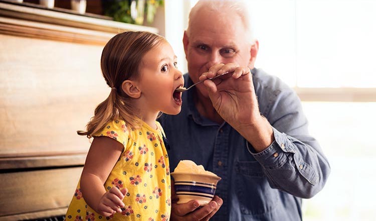 A grandfather serving his granddaughter Blue Bell Ice Cream