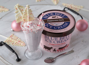 Blue Bell Peppermint Bark Milkshake with crushed peppermint candies and white chocolate tree toppers.