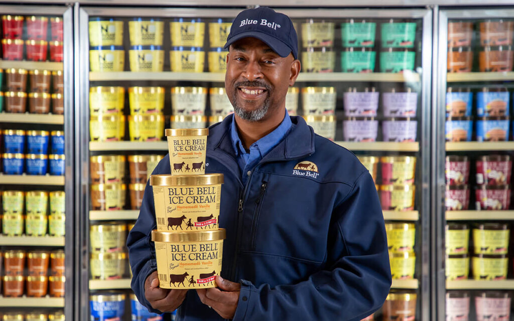 Blue Bell employee stocking ice cream at a grocery store