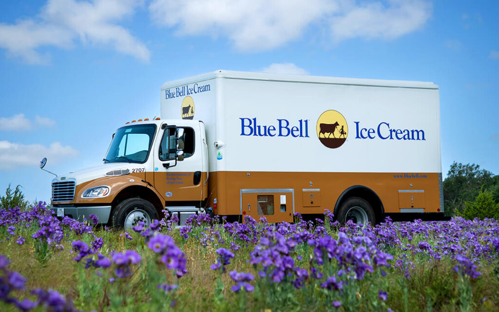 Blue Bell Ice Cream bobtail truck in a field of bluebell flowers